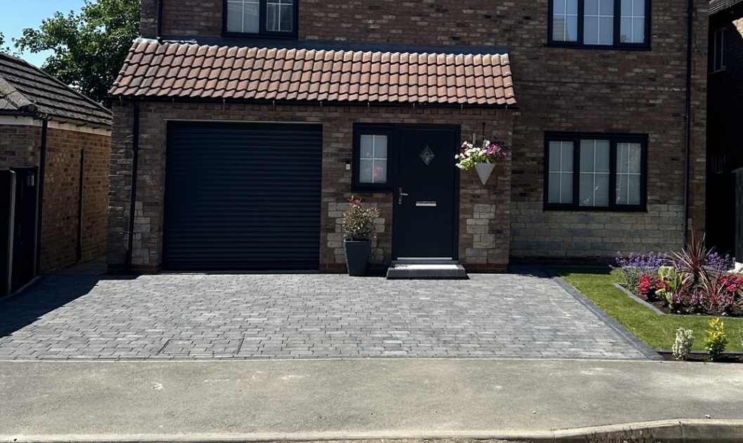 modern block paved driveway and front garden outside brick house